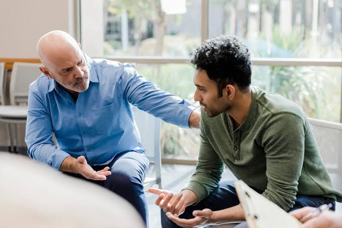Counselor supporting a client in a group clinic setting